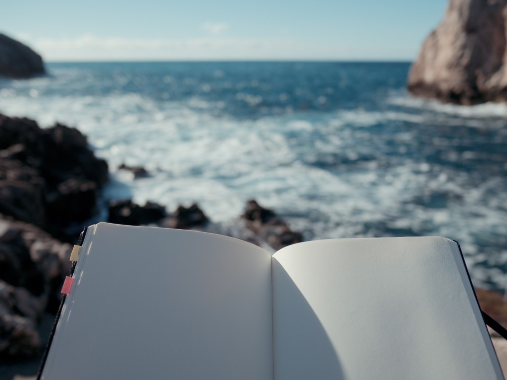 blank sketchbook open near the sea