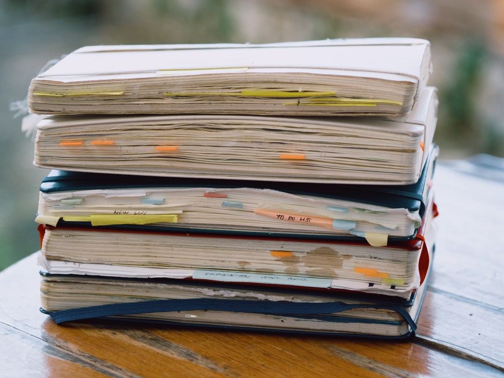 stack of sketchbooks on a table