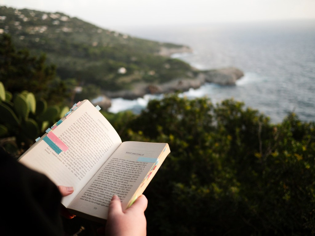seascape views of someone reading a book by the sea